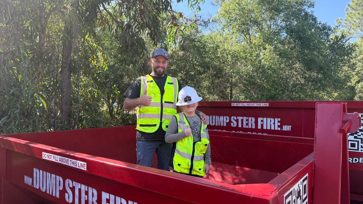 Tyler Heeb and one of his kids on a job with a red Dumpster Fire dumpster in Southwest Florida.