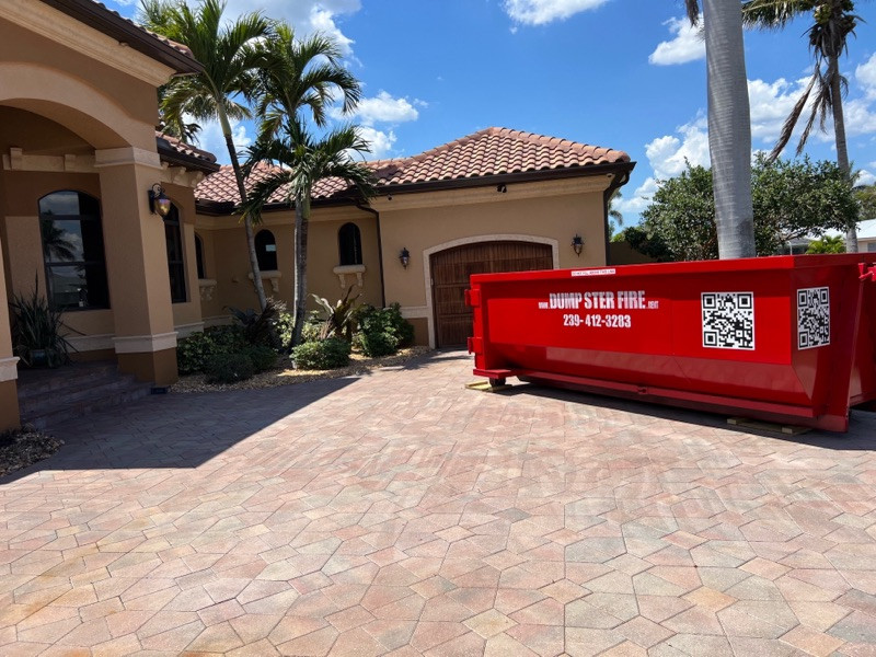 A red Dumpster Fire roll-off dumpster at a Southwest Florida home
