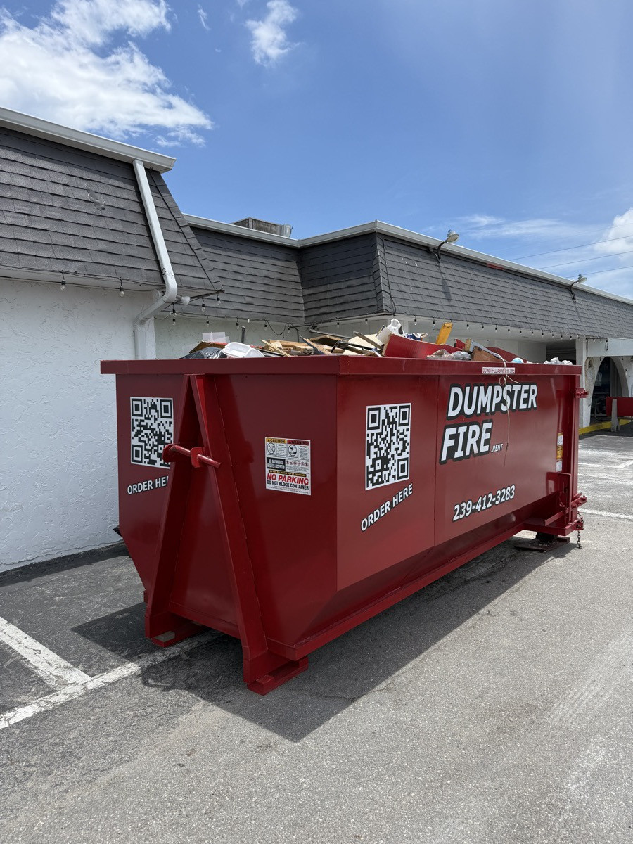 A loaded red Dumpster Fire roll-off dumpster ready for pickup near Punta Gorda, FL