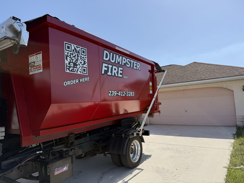 A red Dumpster Fire roll-off dumpster in a Southwest Florida driveway