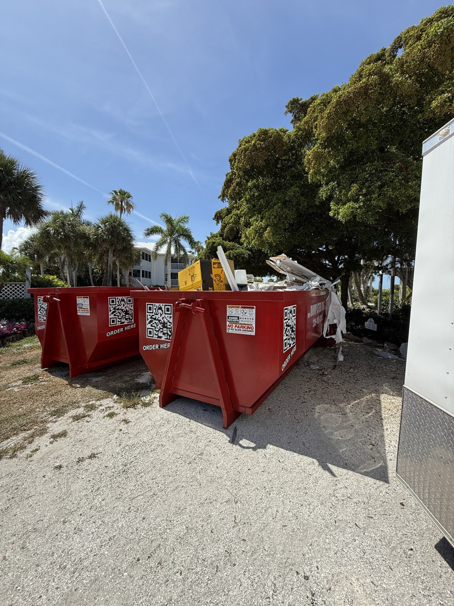 A red Dumpster Fire roll-off dumpster filling up on a job near Alva, FL