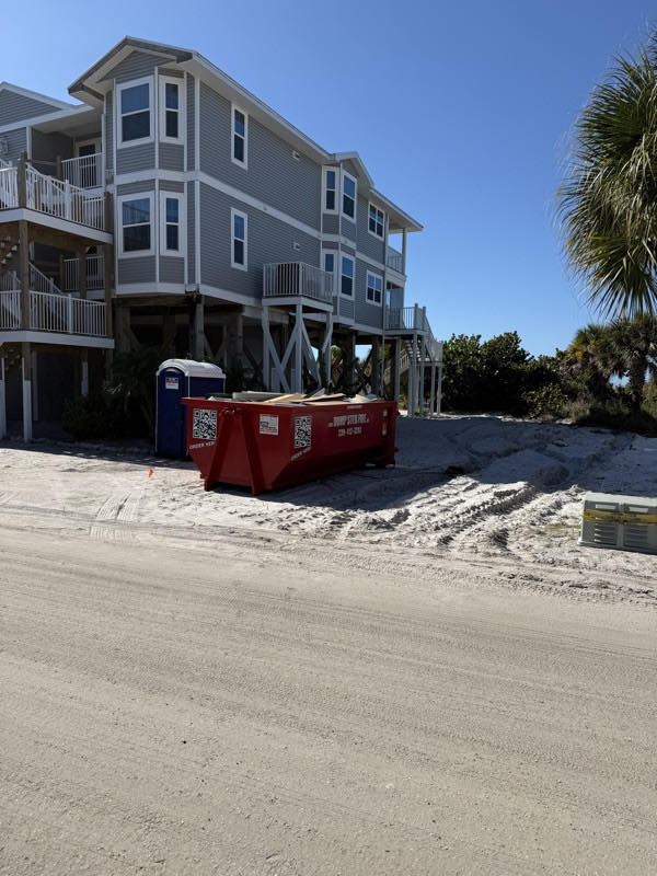A red Dumpster Fire roll-off dumpster in a Southwest Florida driveway