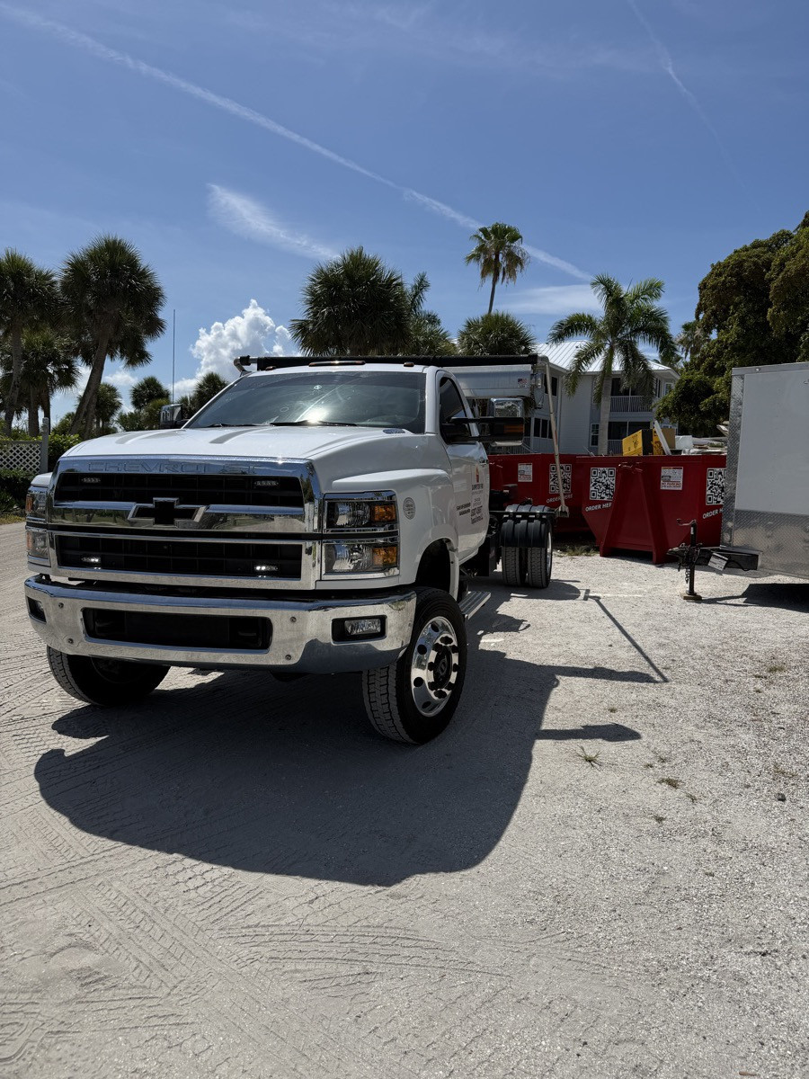 The Dumpster Fire truck and a red roll-off dumpster on a job near North Port, FL